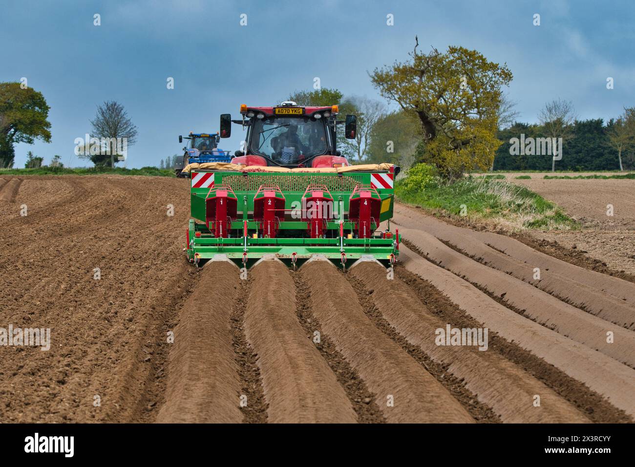 Tracteurs effectuant des forages profonds sur lit, préparant la plantation de pommes de terre au printemps sur des terres agricoles à Norfolk (Hickling) East Anglia UK. Banque D'Images
