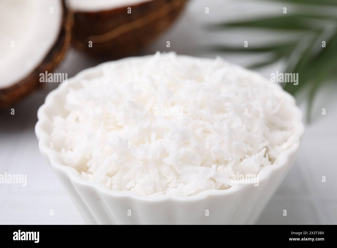 Flocons de noix de coco dans un bol sur la table, gros plan Banque D'Images