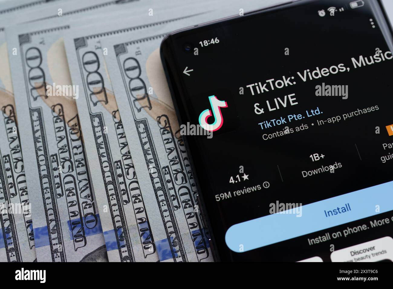 Application TikTok vu sur l'écran du smartphone qui est placé sur des dollars américains. Stafford, Royaume-Uni, 28 avril 2024 Banque D'Images