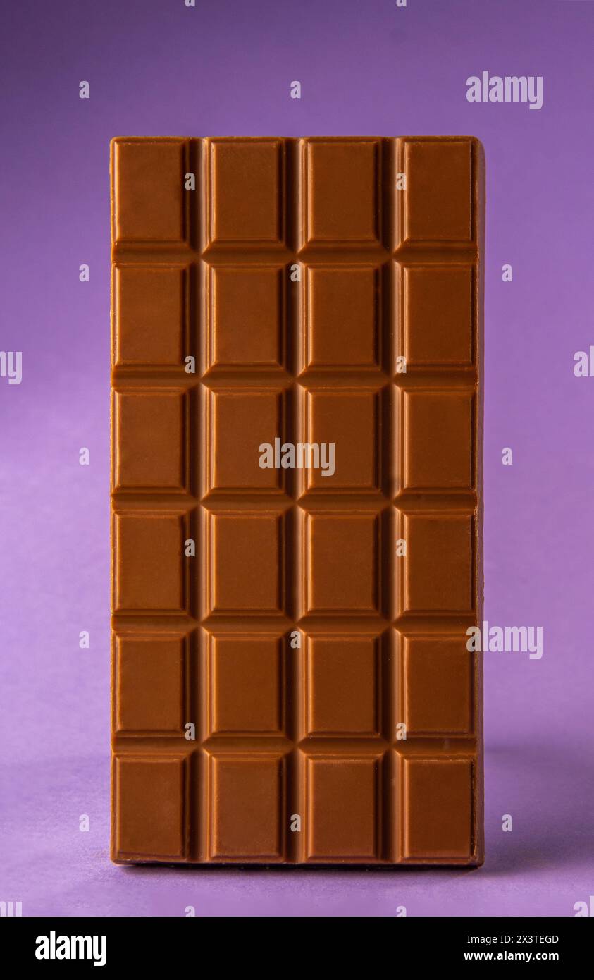 barre de chocolat isolée sur fond violet. Concept de journée internationale du chocolat Banque D'Images