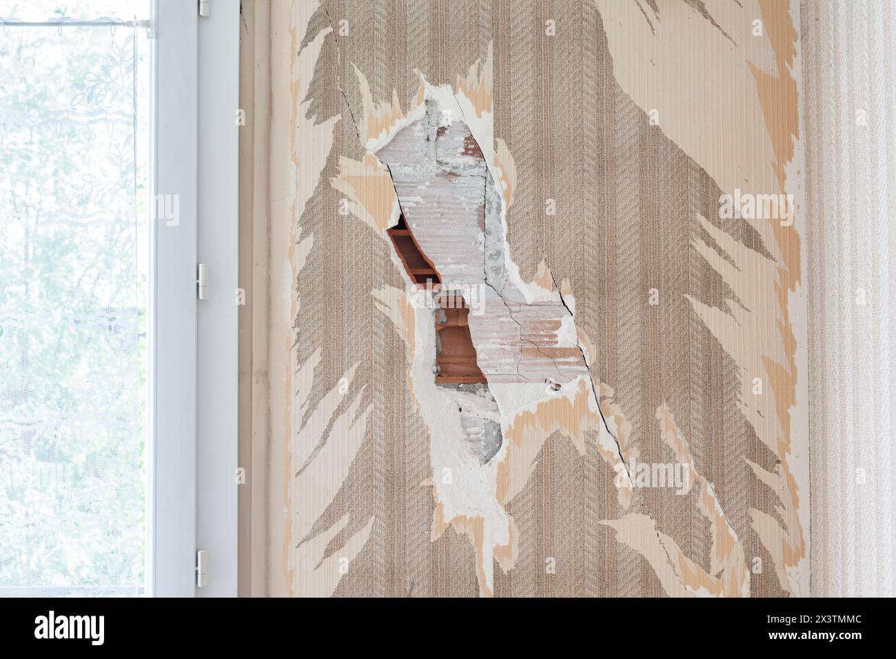 Fissures dans un mur de briques dans un appartement. Banque D'Images
