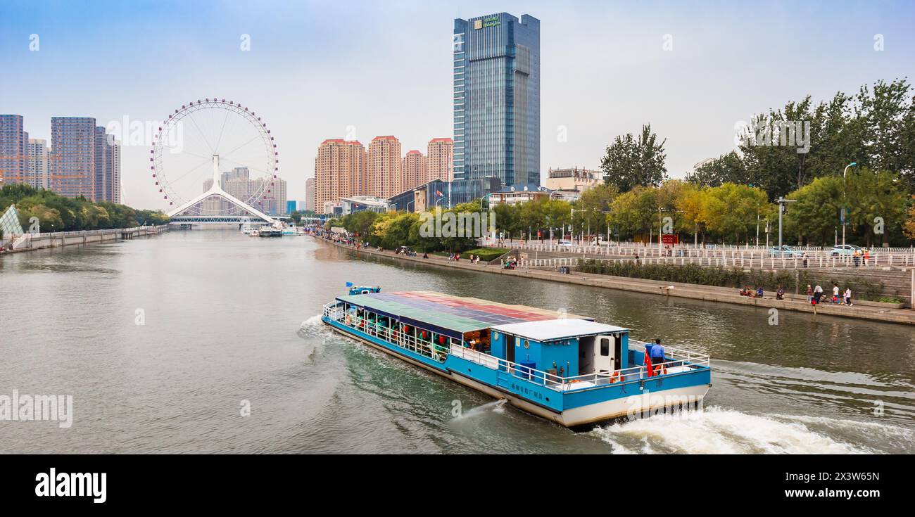 Panorama d'un bateau touristique naviguant vers la grande roue Tianjin Eye à Tianjin, Chine Banque D'Images