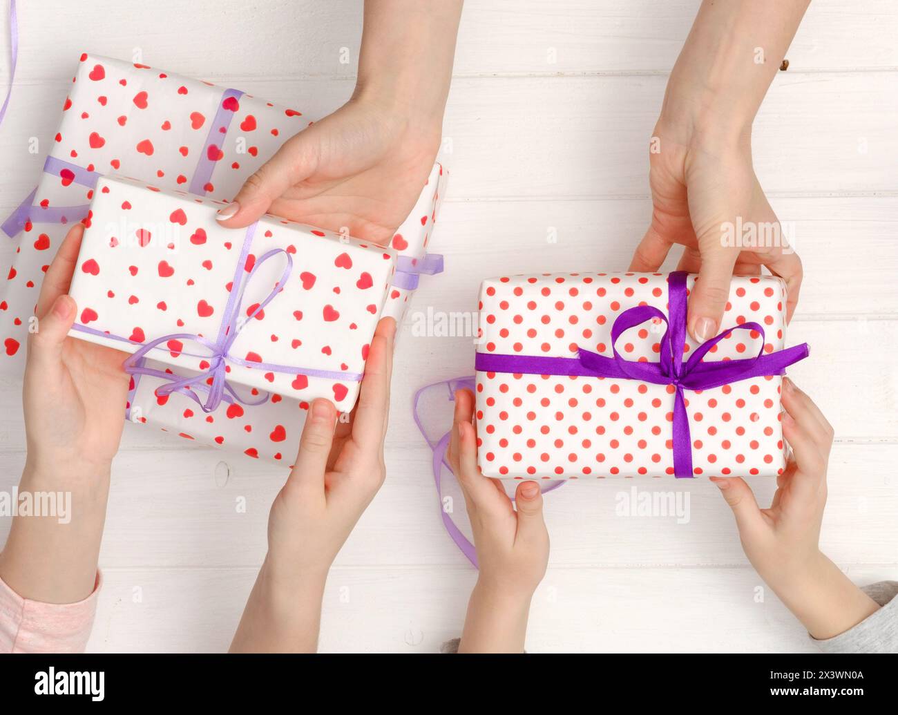 Vue de dessus des mains féminines tenant des cadeaux pour l'anniversaire, la Saint-Valentin, Noël, nouvel an, fête des mères. Pose à plat Banque D'Images