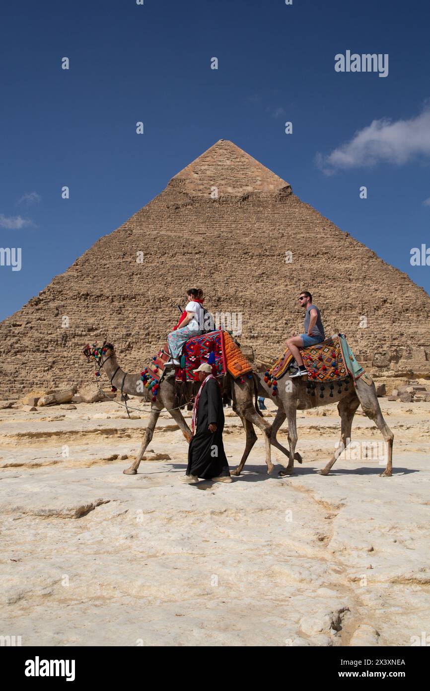 Touristes sur chameaux, Pyramide de Khafre (également appelé Chephren) (arrière-plan), complexe de pyramides de Gizeh, site du patrimoine mondial de l'UNESCO, Gizeh, Egypte Banque D'Images