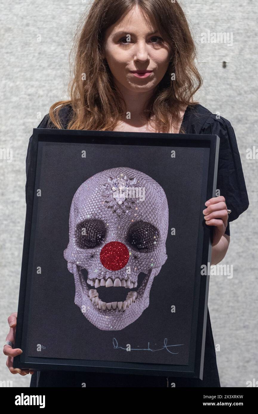 Londres, Royaume-Uni. 29 avril 2024. Un membre du personnel de 'for the Love of Comic relief', 2013, (est. £3 000 - £5 000) de Damien Hirst lors de l'avant-première de 'Hot Off the Press', une vente de gravures et de nouvelles éditions, créées et publiées au cours des cinquante dernières années, par des artistes contemporains bien connus. Les œuvres seront vendues aux enchères à Bonhams New Bond Street le 1er mai. Credit : Stephen Chung / Alamy Live News Banque D'Images