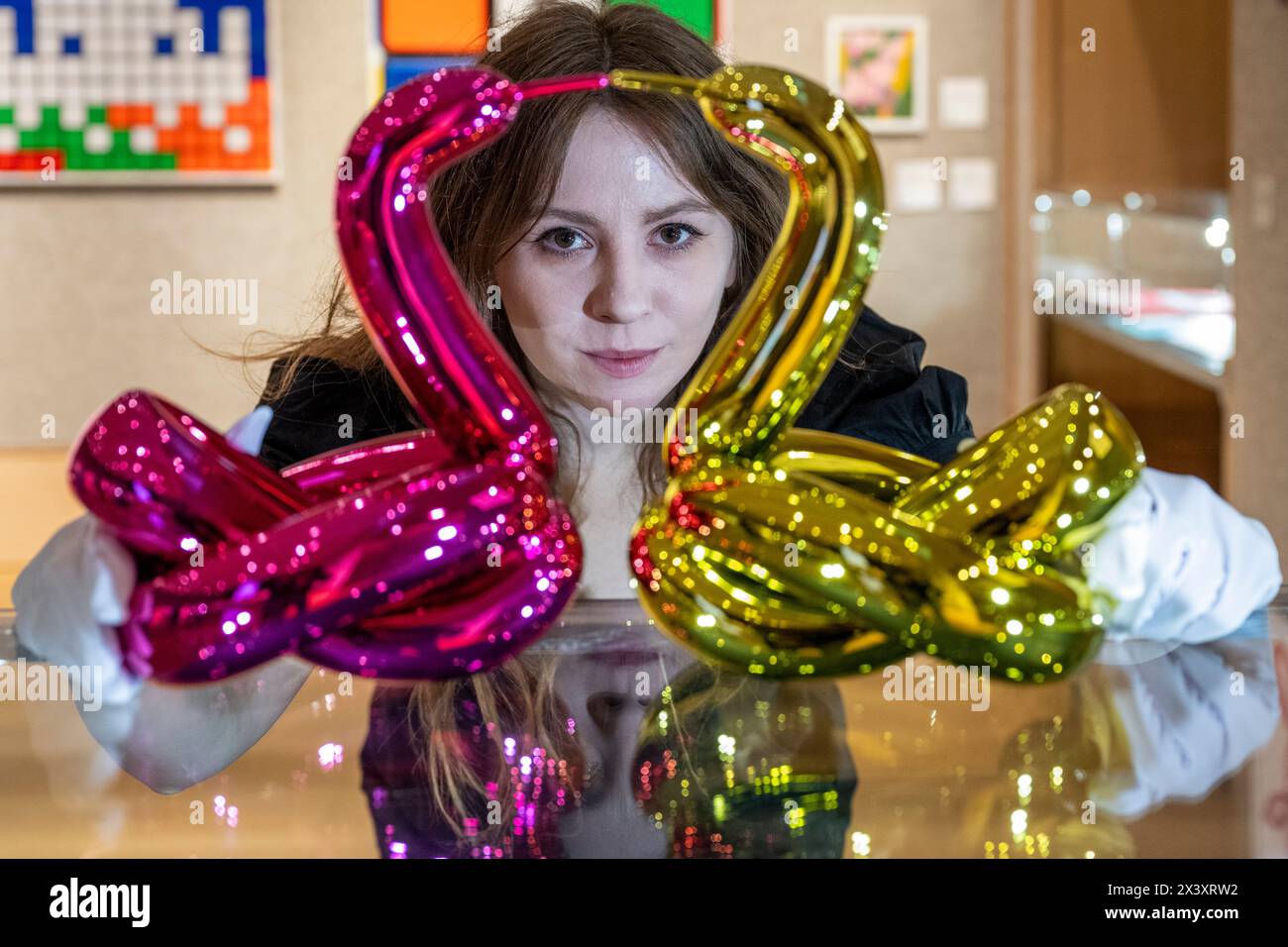 Londres, Royaume-Uni. 29 avril 2024. Un membre du personnel avec deux œuvres des six 'Balloon Animals Collector's Set', 2017-2019, de Jeff Koons, (est. £50 000 - £70,000), en avant-première de 'Hot Off the Press', une vente de tirages et de nouvelles éditions, créées et publiées au cours des cinquante dernières années, par des artistes contemporains bien connus. Les œuvres seront vendues aux enchères à Bonhams New Bond Street le 1er mai. Credit : Stephen Chung / Alamy Live News Banque D'Images