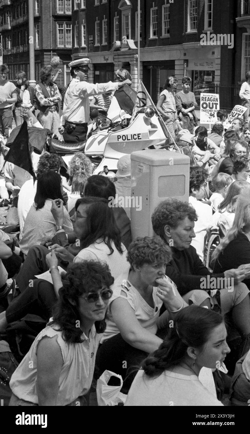 Londres, Royaume-Uni. 9 juin 1984. Des activistes non violents à action directe s'assoient dans les rues menant à Grosvenor Square, Londres, le 9 juin 1984. L'action était en réponse à la visite du président américain Ronald Reagan au Sommet économique mondial de Londres et au déploiement de missiles de croisière américains au Royaume-Uni. La manifestation a coïncidé avec le rassemblement de missiles anti-croisière du CND à Trafalgar Square. Londres. Grosvenor Square était l'emplacement de l'ambassade américaine au Royaume-Uni au moment de la manifestation. Banque D'Images