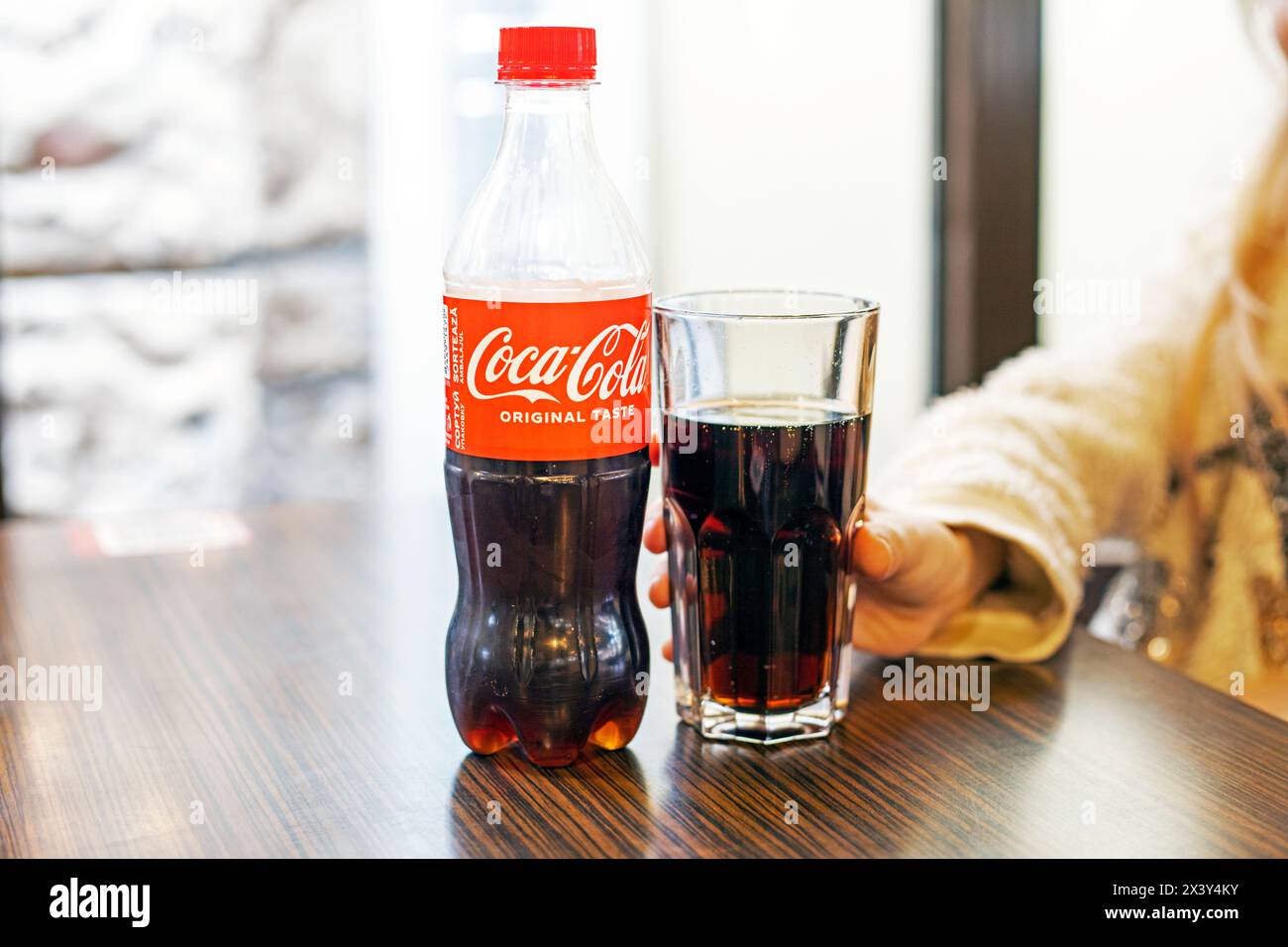 Fille tient un verre pour Coca-Cola dans un café à Ivano Frankovs, Ukraine le 31 2024 mars Banque D'Images