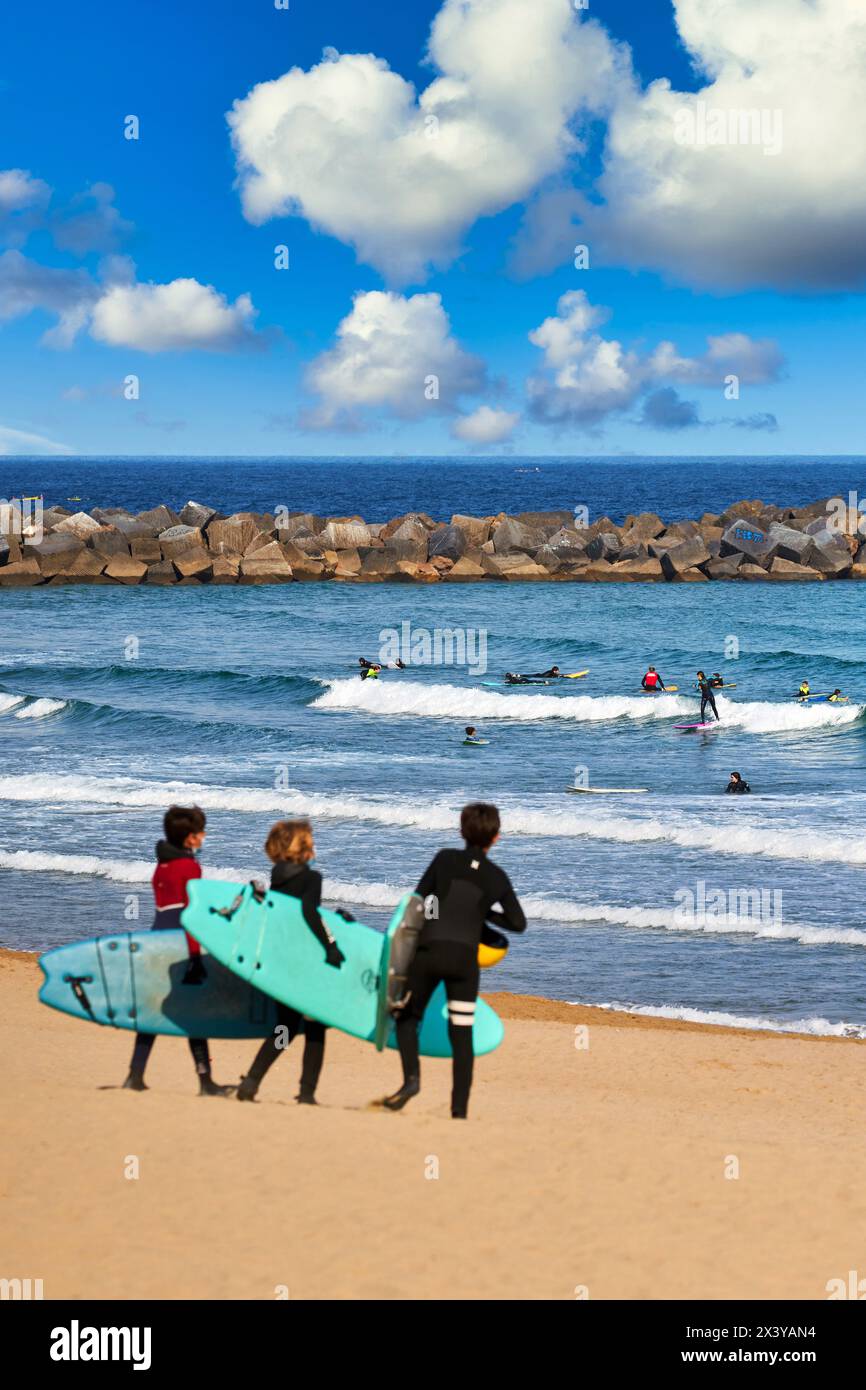 Groupe de jeunes prennent un cours de surf sur la plage de la Zurriola, Donostia, Saint-Sébastien, pays Basque, Espagne, Europe. La Zurriola est la beac de surf Banque D'Images