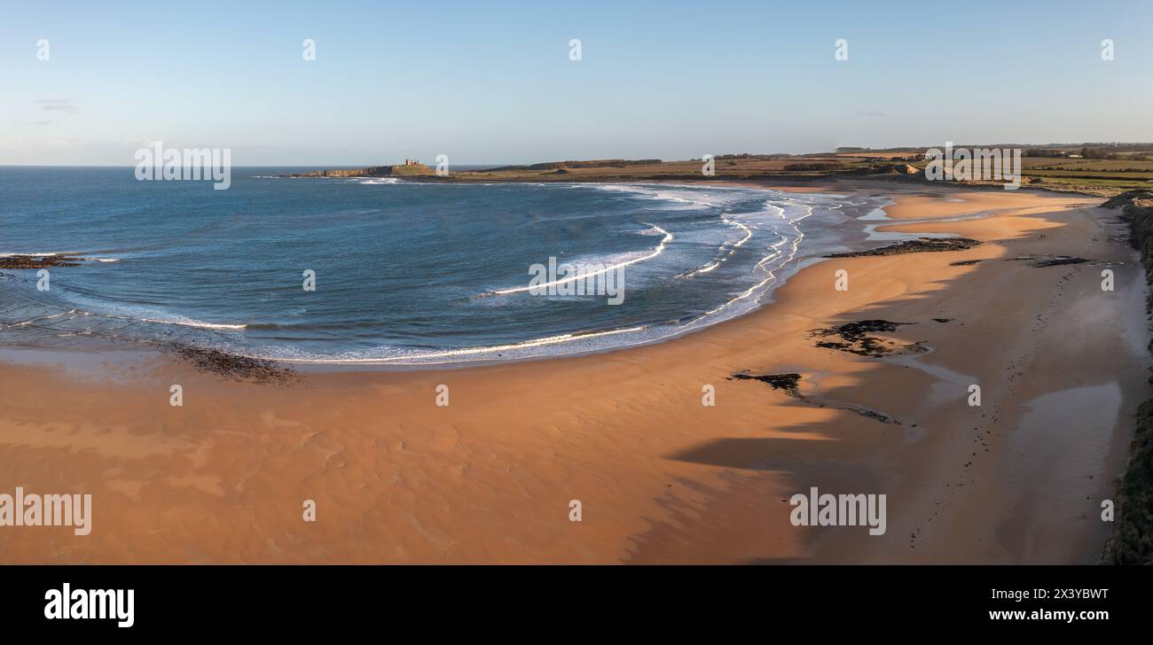 Vue panoramique aérienne du sentier de la côte d'Angleterre le long de la plage d'Embleton Bay et du château de Dunstanburgh au coucher du soleil Banque D'Images
