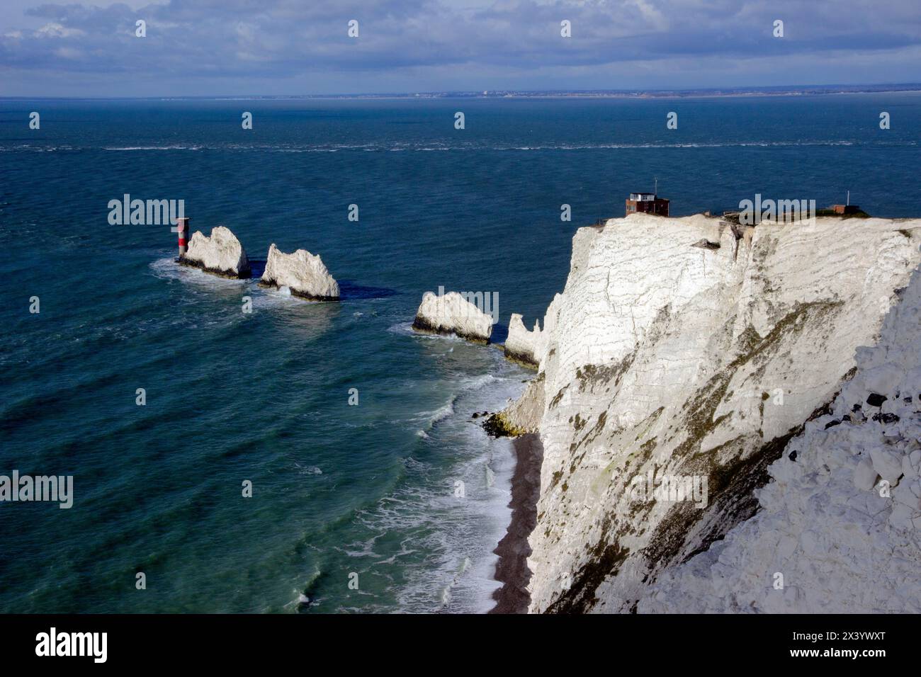 The Needles, une rangée de trois piles de craie au large de la côte ouest de l'île de Wight, s'élevant à environ 30 m de la mer, avec le phare Needles au-delà Banque D'Images