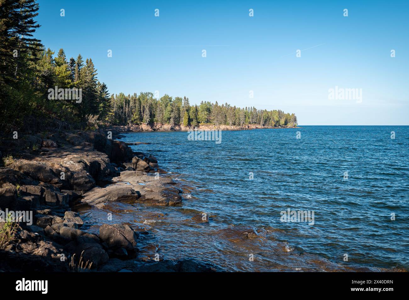 Paysage magnifique le long de la rive nord rocheuse et bordée d'arbres du lac supérieur dans le Minnesota, avec l'eau bleue et le ciel sur un bel après-midi ensoleillé. G Banque D'Images