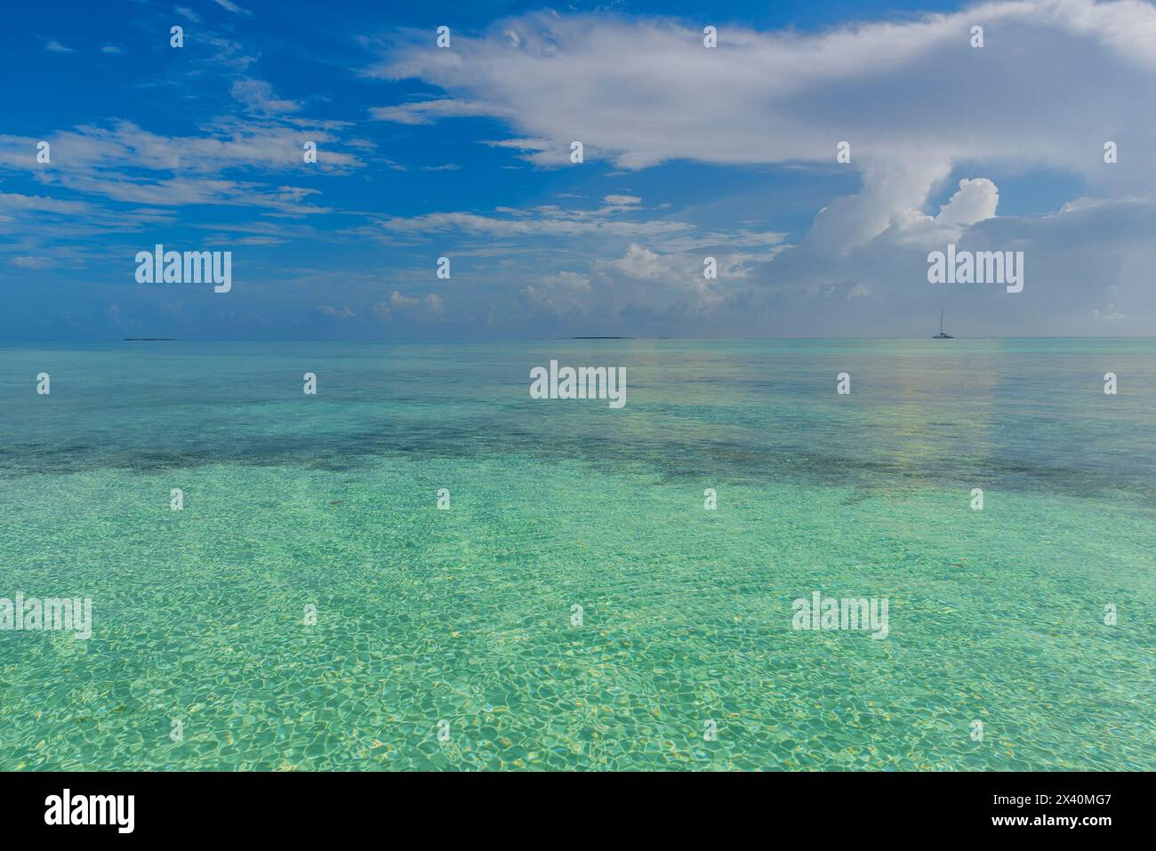 Vue sur l'eau turquoise au large de la plage d'une station balnéaire à Cayo Guillermo avec un bateau à l'horizon ; Cayo Guillermo, Jardines del Rey, Cuba Banque D'Images
