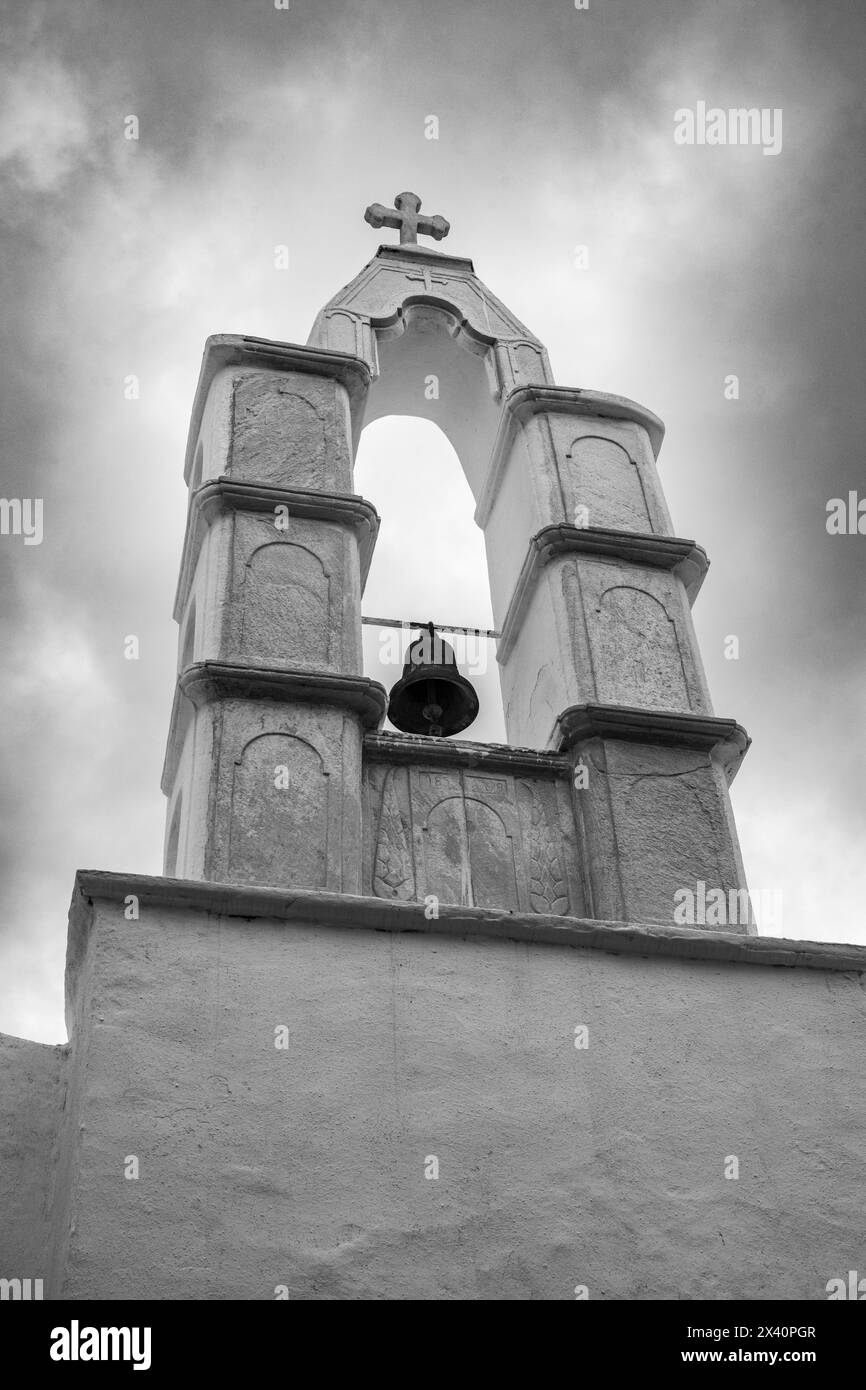 Image en noir et blanc du clocher historique d'une église contre un ciel nuageux sur l'île de Mykonos ; Mykonos, Grèce Banque D'Images