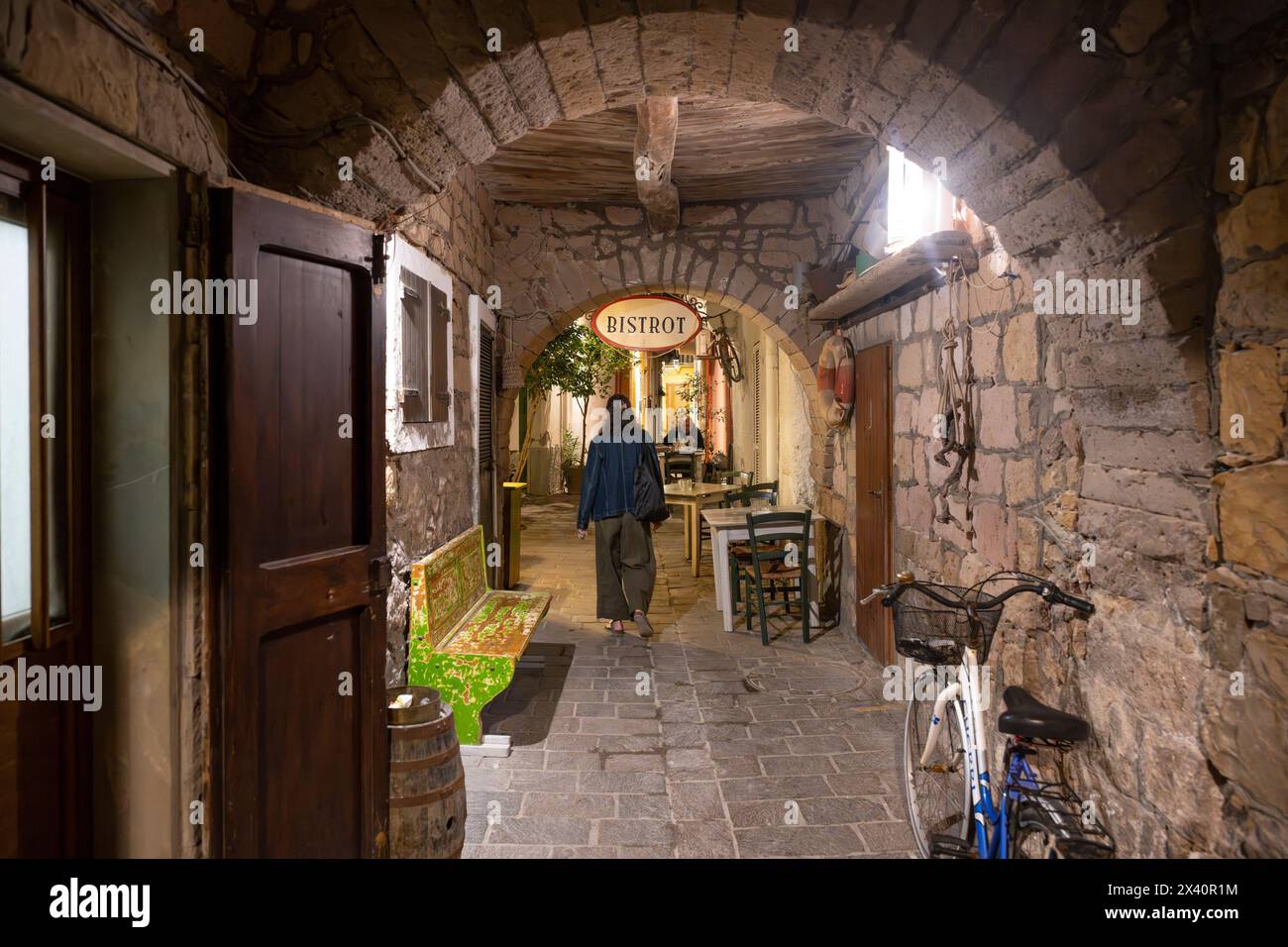 Femme marche à travers une passerelle étroite avec des murs de pierre et des arches dans la province de Sardaigne du Sud, Italie ; Carloforte, Sardaigne du Sud, Italie Banque D'Images