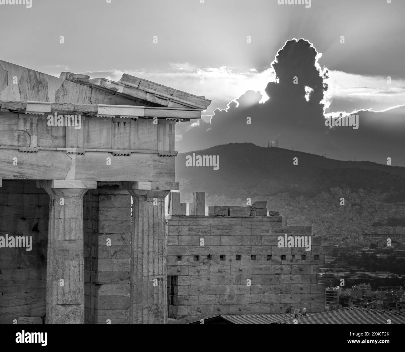 Architecture à l'Acropole d'Athènes et une vue sur la ville d'Athènes au coucher du soleil, avec la lumière du soleil derrière une formation de nuages dans le ciel faisant un DRAM... Banque D'Images