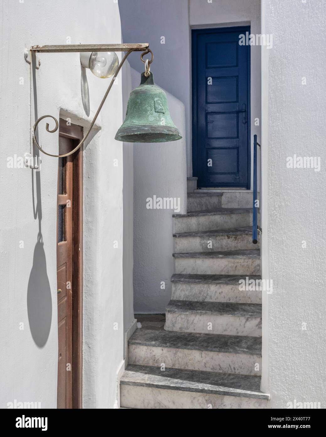 Cloche montée au-dessus de la porte sur un bâtiment blanchi en Grèce ; Ano Mera, sud de la mer Égée, Grèce Banque D'Images