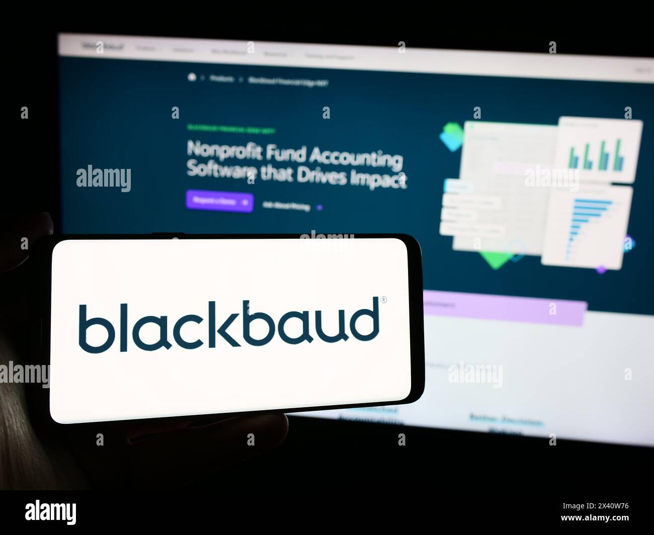 Personne tenant le téléphone portable avec le logo de la société américaine de logiciels Blackbaud Inc. en face de la page Web de l'entreprise. Concentrez-vous sur l'affichage du téléphone. Banque D'Images