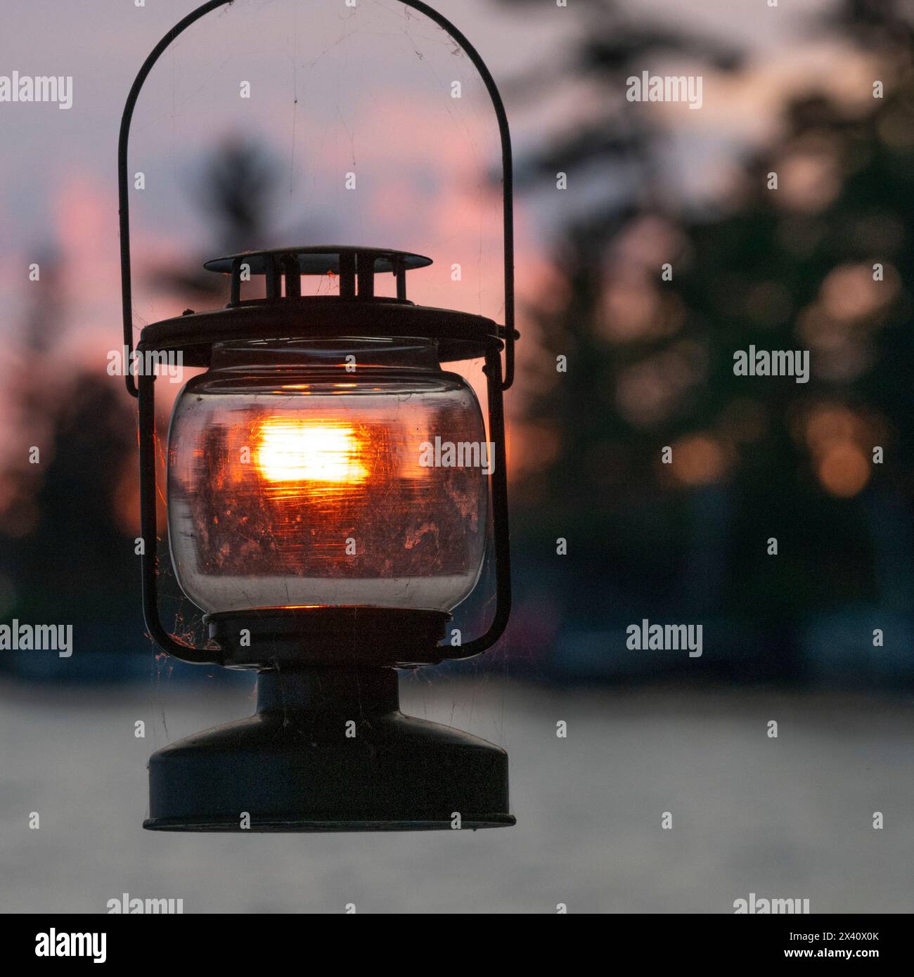 La lumière du coucher de soleil brille et illumine le verre d'une lanterne en métal noir ; Lake of the Woods, Ontario, Canada Banque D'Images