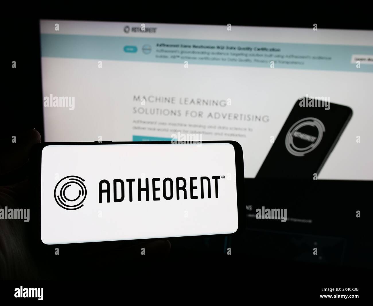 Personne tenant le téléphone portable avec le logo de la société américaine de logiciel de publicité AdTheorent Inc en face de la page Web. Concentrez-vous sur l'affichage du téléphone. Banque D'Images