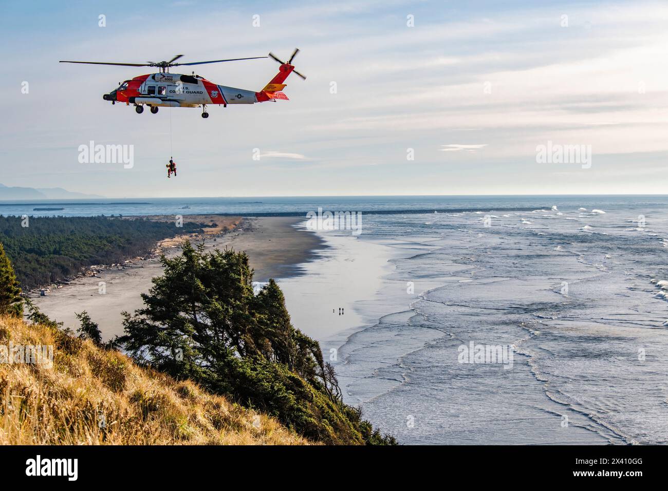 L'équipage de la Garde côtière américaine suspendu en dessous d'un Sikorsky MH-60J Jayhawk effectuant des exercices de sauvetage au parc d'État Cape Disception près du Mo... Banque D'Images