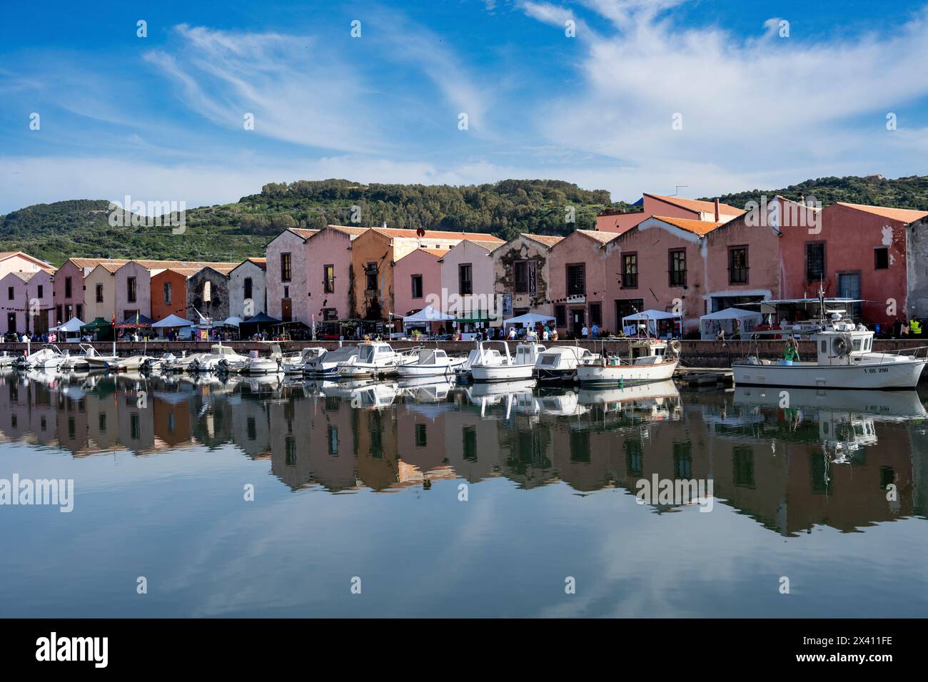 Bateaux amarrés dans le port tranquille de Bosa, avec des bâtiments et des bateaux reflétés dans l'eau. Bosa est situé à environ deux tiers du chemin jusqu'à la ... Banque D'Images