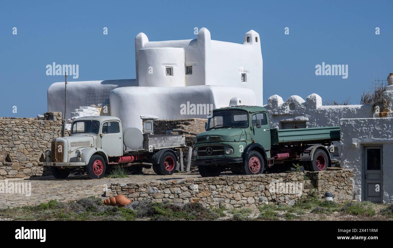Camionnettes et un bâtiment de blanchissage à la chaux en construction avec un ciel bleu vif sur l'île de Mykonos ; Ano Mera, sud de la mer Égée, Grèce Banque D'Images