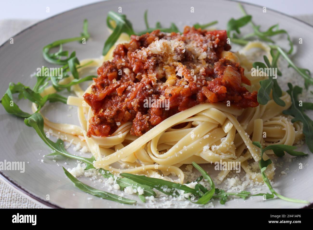 Linguine bolognaise traditionnelle avec du parmesan rasé et de l'Arugula fraîche Banque D'Images