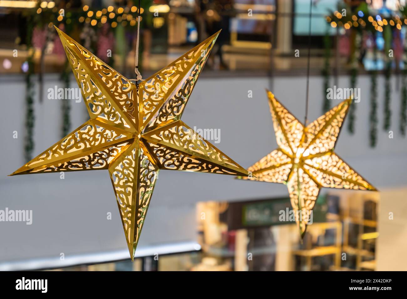 Vue rapprochée de la décoration des étoiles brillantes accrochée dans le centre commercial pendant la célébration Joyeux Noël. Banque D'Images
