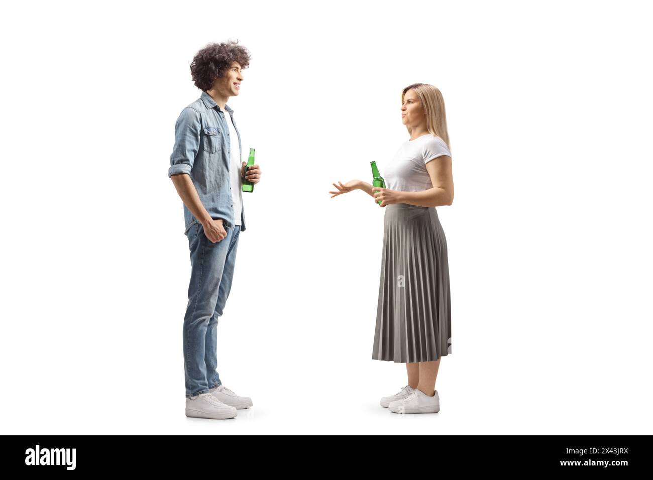 Plein plan de profil d'un jeune homme et d'une femme tenant des bouteilles de bière et parlant isolé sur fond blanc Banque D'Images