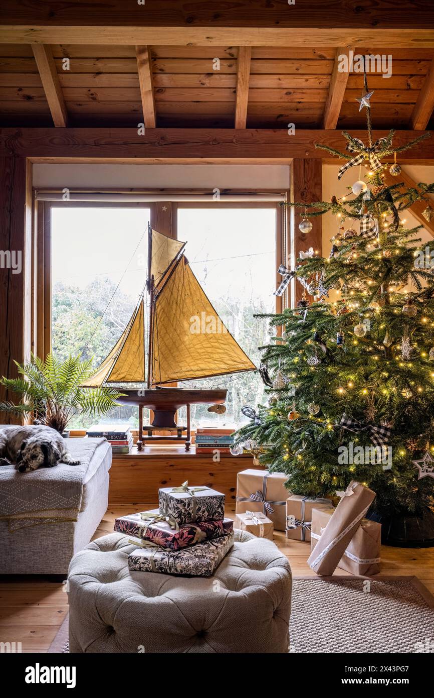 Yacht modèle dans la fenêtre avec arbre de Noël dans la maison East Sussex, South East England, Royaume-Uni Banque D'Images