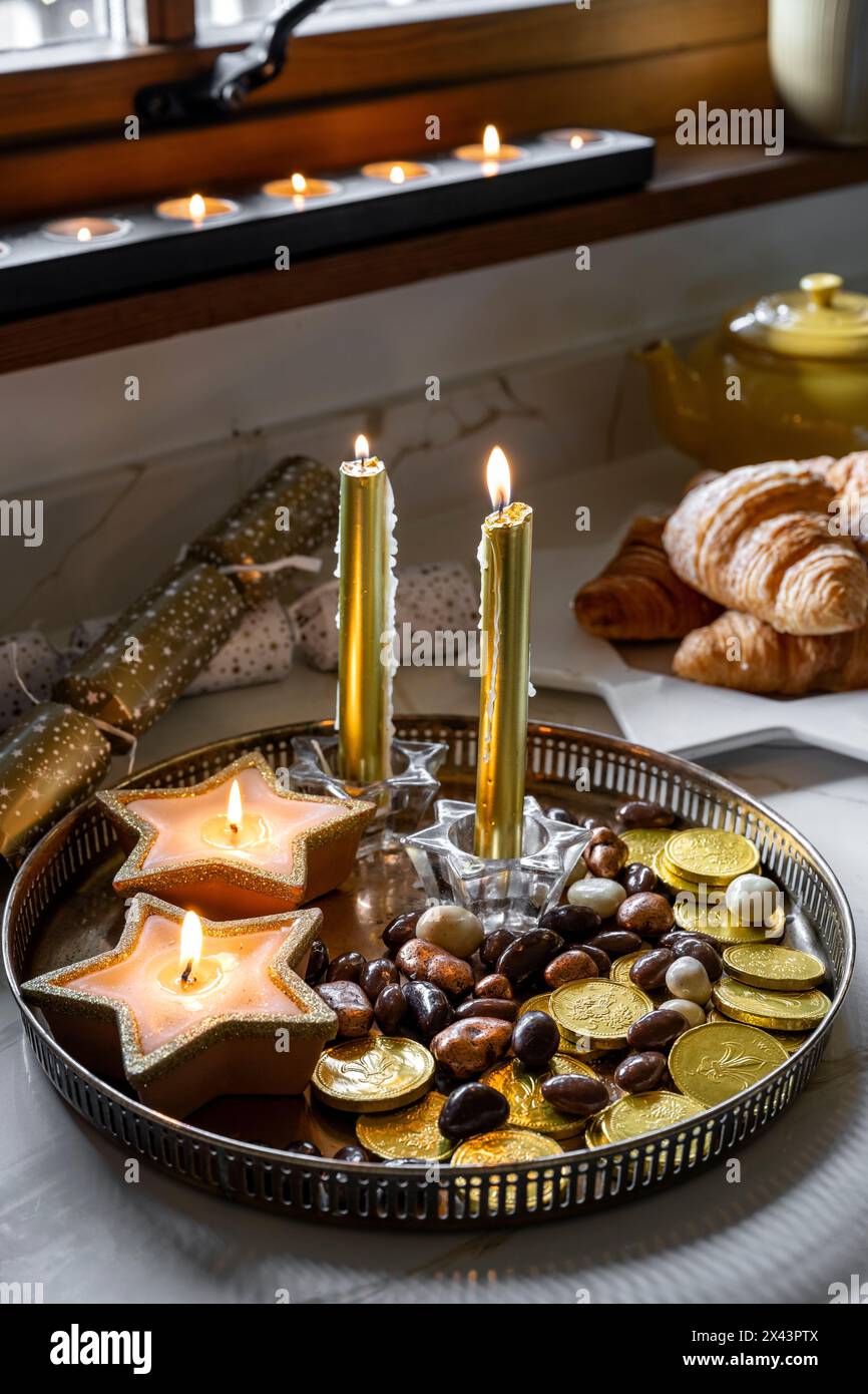 Bougies allumées avec des pièces de monnaie et des noix à Noël dans la maison East Sussex, sud-est de l'Angleterre, Royaume-Uni Banque D'Images
