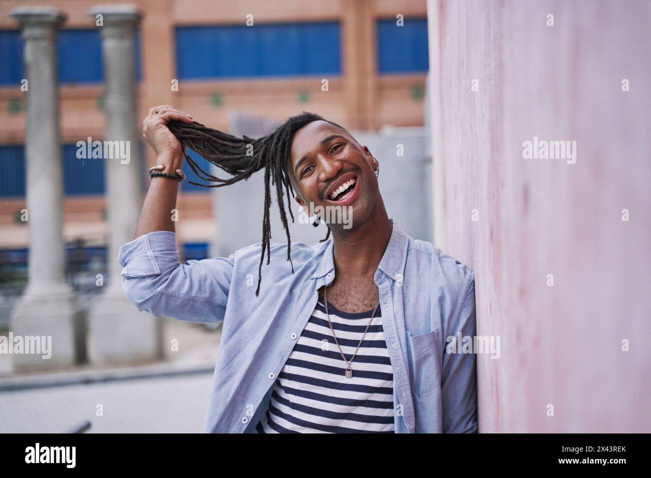 portrait humoristique d'un jeune homme noir tirant ses tresses loin de son visage Banque D'Images