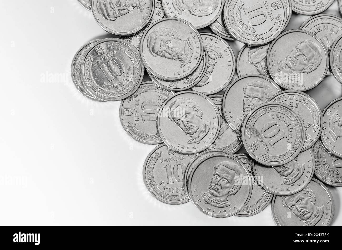 Un tas de pièces d'argent brillantes crée un beau motif sur une surface blanche, ressemblant à un cercle. La monnaie métallique peut être utilisée pour l'épargne ou craf Banque D'Images