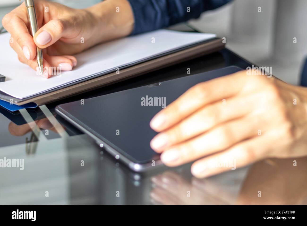 Gros plan de la femme avec de belles mains dans la tenue d'affaires, travaillant sur la tablette dans le bureau, prenant des notes Banque D'Images