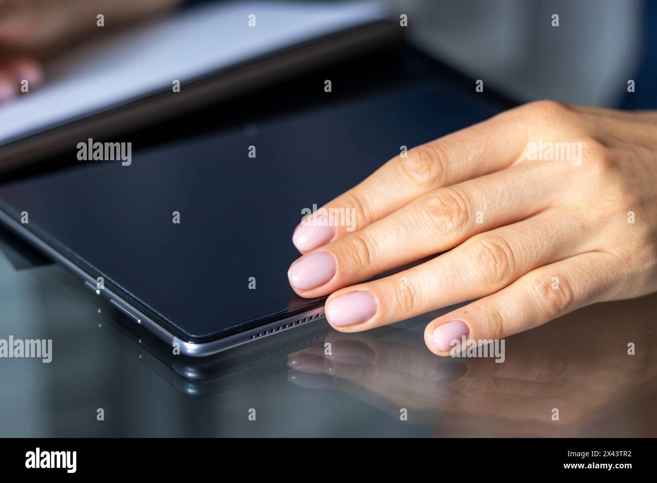 Gros plan de la femme avec de belles mains dans la tenue d'affaires, travaillant sur la tablette dans le bureau, prenant des notes Banque D'Images