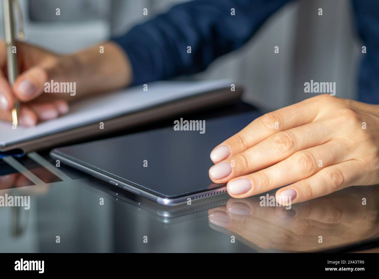 Gros plan de la femme avec de belles mains dans la tenue d'affaires, travaillant sur la tablette dans le bureau, prenant des notes Banque D'Images