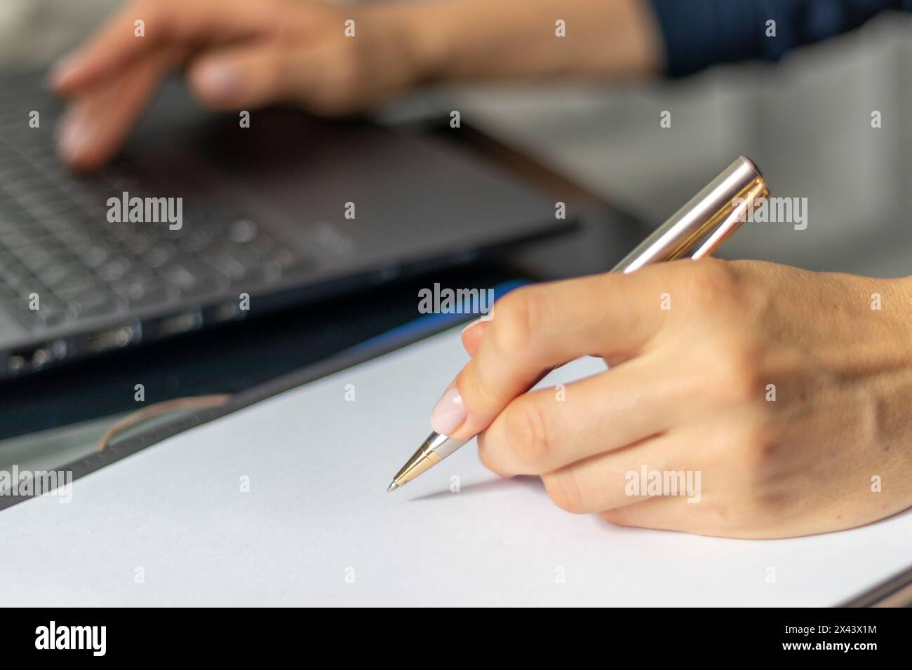 Gros plan de la femme avec de belles mains dans la tenue d'affaires, travaillant sur l'ordinateur portable dans le bureau, prenant des notes Banque D'Images