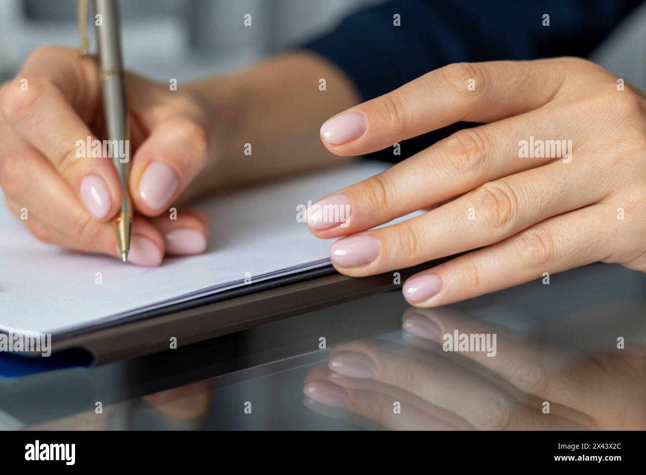 Gros plan de la femme avec de belles mains dans la tenue d'affaires, travaillant au bureau, prenant des notes Banque D'Images