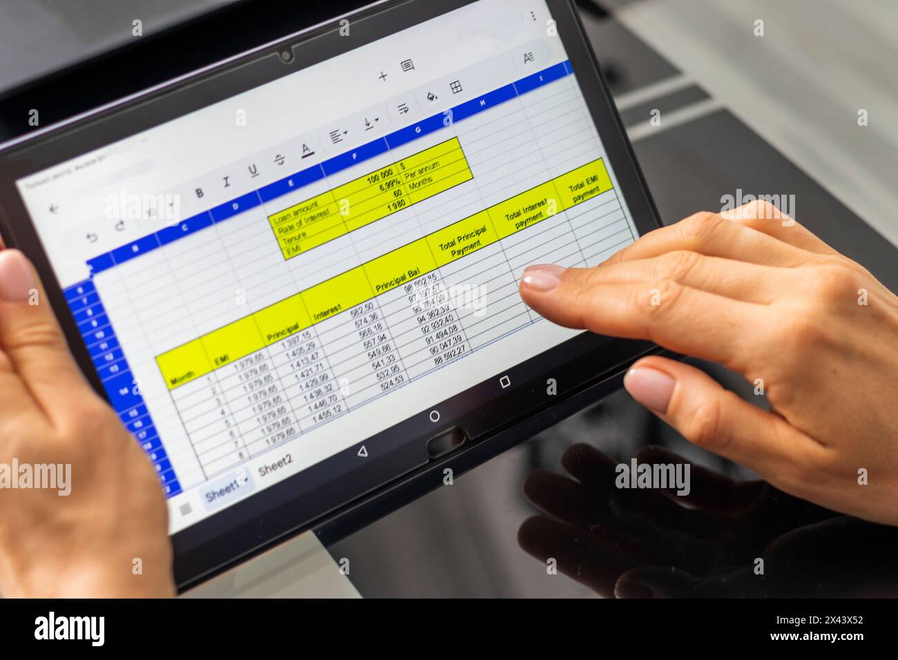 Gros plan de la femme avec de belles mains , en utilisant la tablette, étudier la table d'amortissement du prêt hypothécaire Banque D'Images