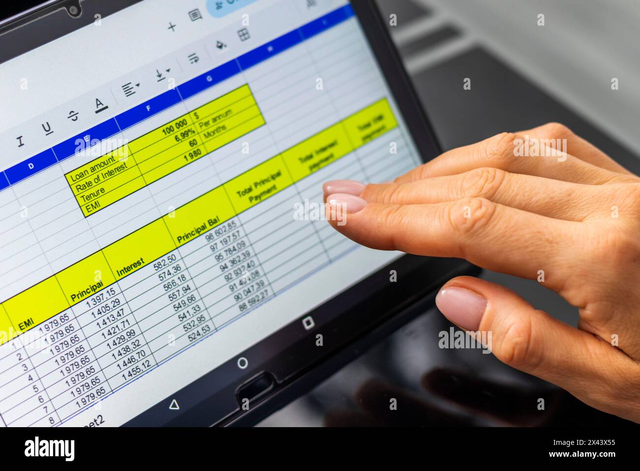 Gros plan de la femme avec de belles mains , en utilisant la tablette, étudier la table d'amortissement du prêt hypothécaire Banque D'Images