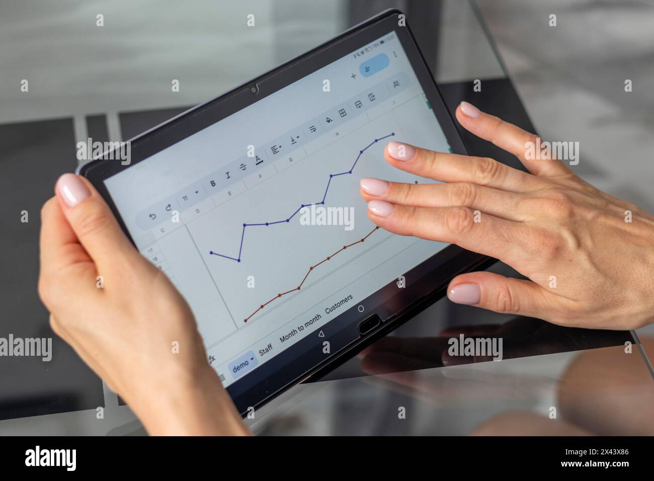 Gros plan de la femme avec de belles mains , en utilisant la tablette, étude du rapport de ventes hypothécaires Banque D'Images