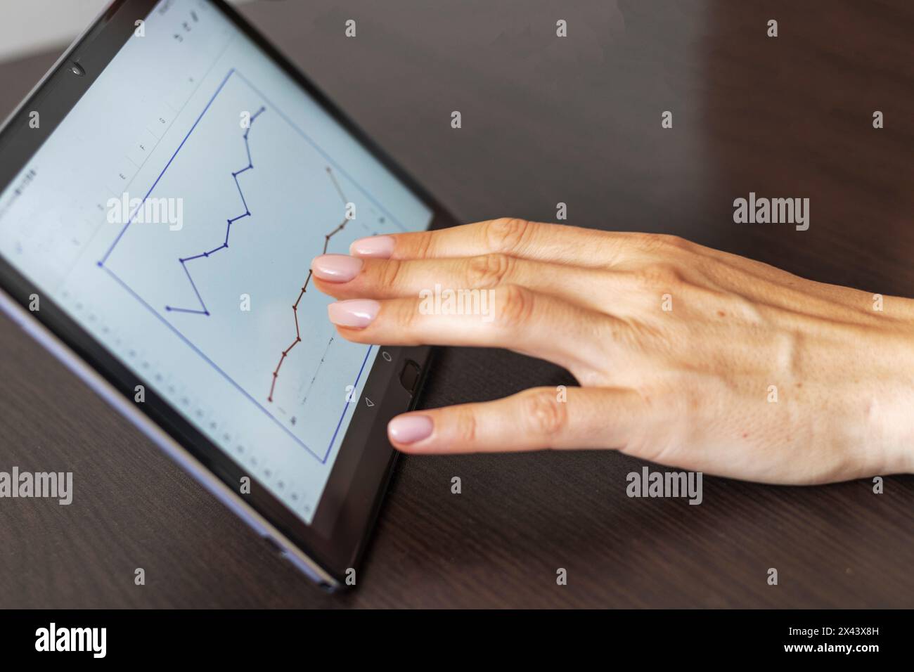 Gros plan de la femme avec de belles mains , en utilisant la tablette, étude du rapport de ventes hypothécaires Banque D'Images