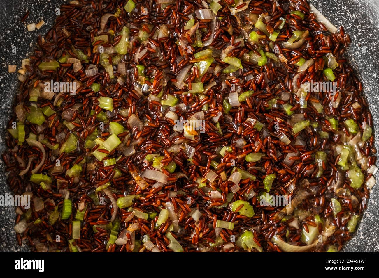 Gros plan vue de dessus de la poêle à frire avec riz rose, oignon et céleri Banque D'Images