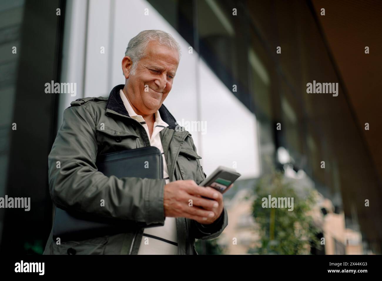 Souriant retraité homme senior utilisant un téléphone intelligent Banque D'Images