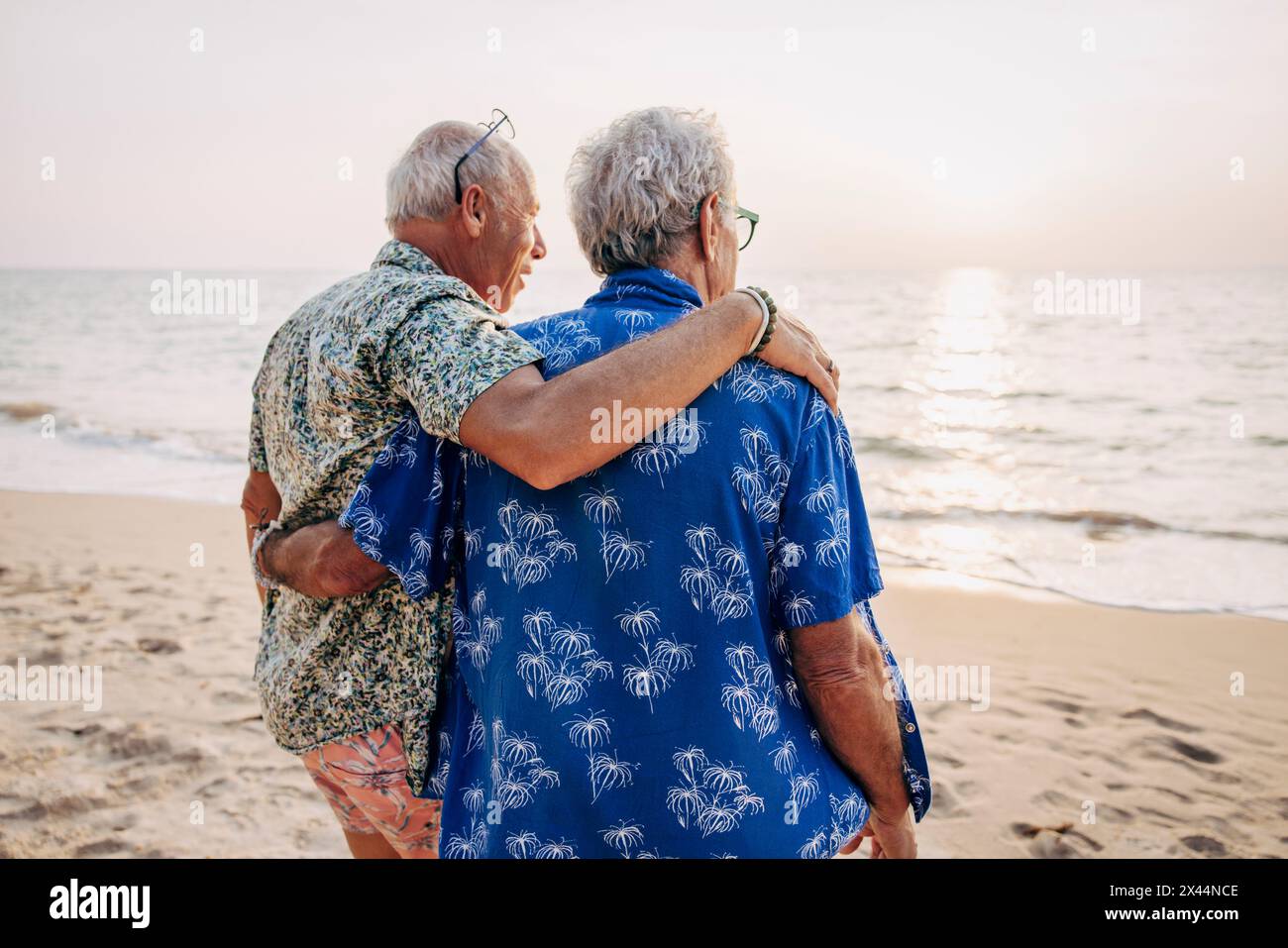 Couple gay avec les bras autour à la plage en vacances Banque D'Images