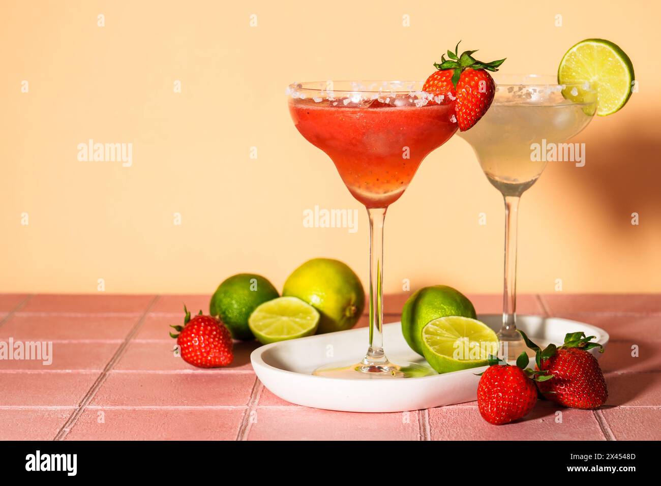Margaritas classiques et à la fraise avec tequila et citron vert sur fond de couleur. Banque D'Images