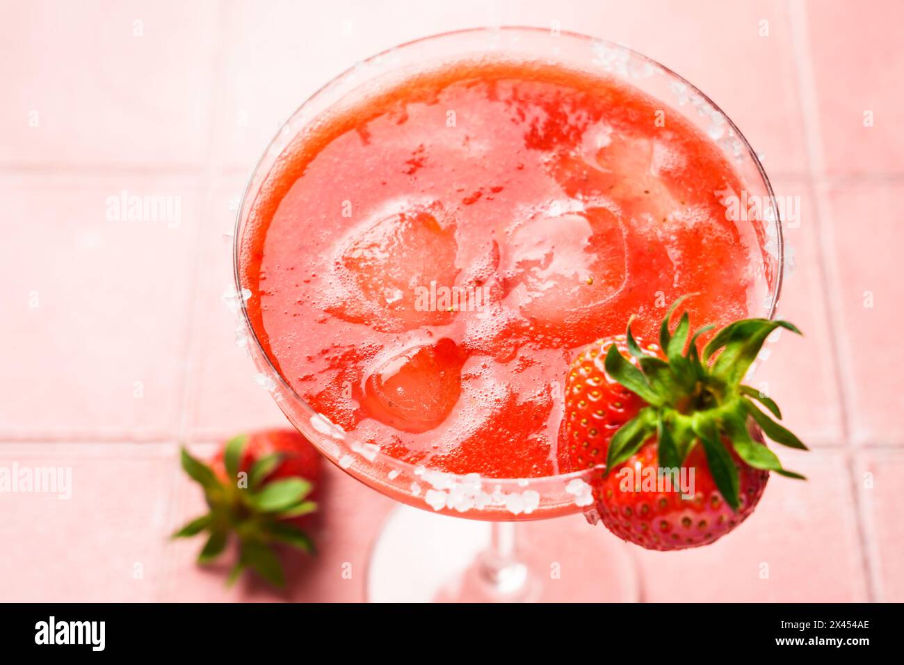 Margarita aux fraises avec tequila, glace, fraise et citron vert sur fond rose. Gros plan. Banque D'Images