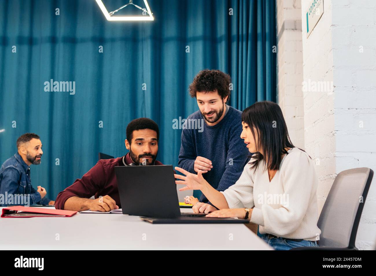 Groupe de personnes de différentes races travaillant concentré et heureux avec des ordinateurs portables dans un bureau de coworking Banque D'Images