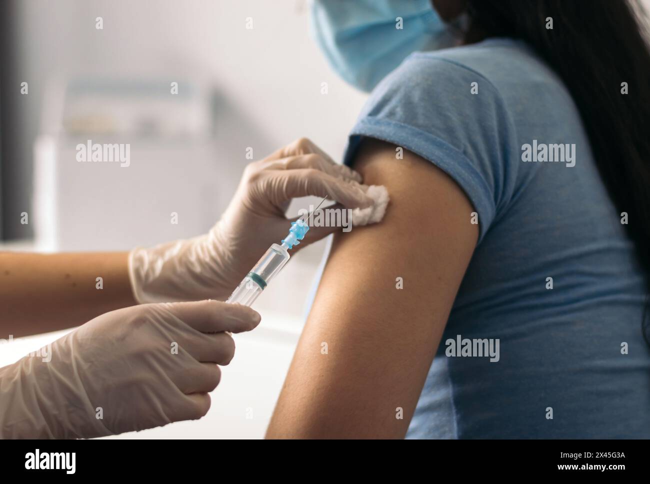 infirmière mettant un vaccin sur un patient avec masque Banque D'Images